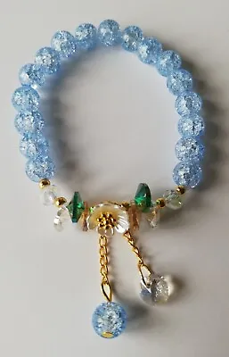 Buy Girls / Ladies Blue Crackle Glass Beaded Bracelet With White Flower Charm  • 3.29£